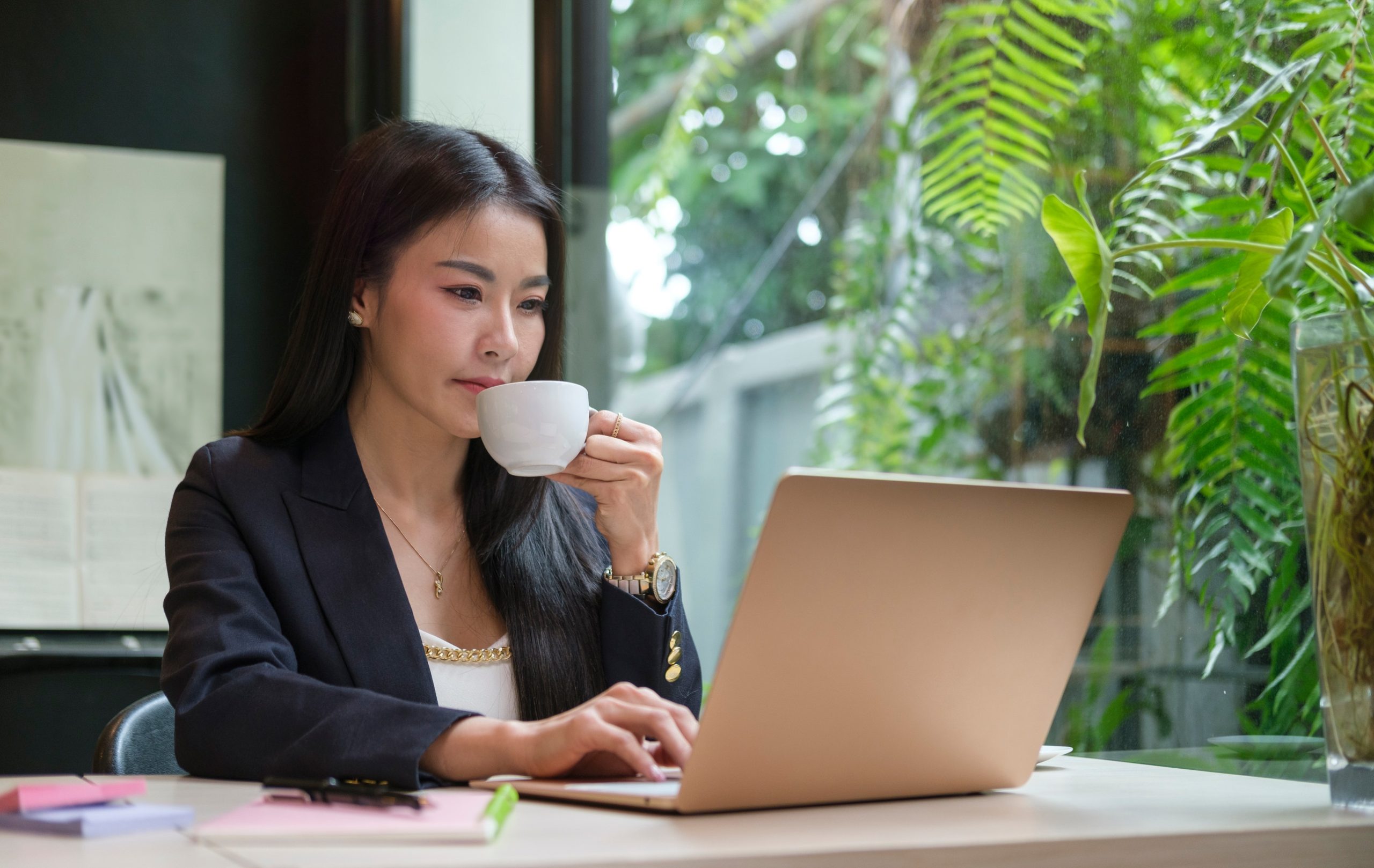 Millennial businesswoman drinking hot coffee and reading email o